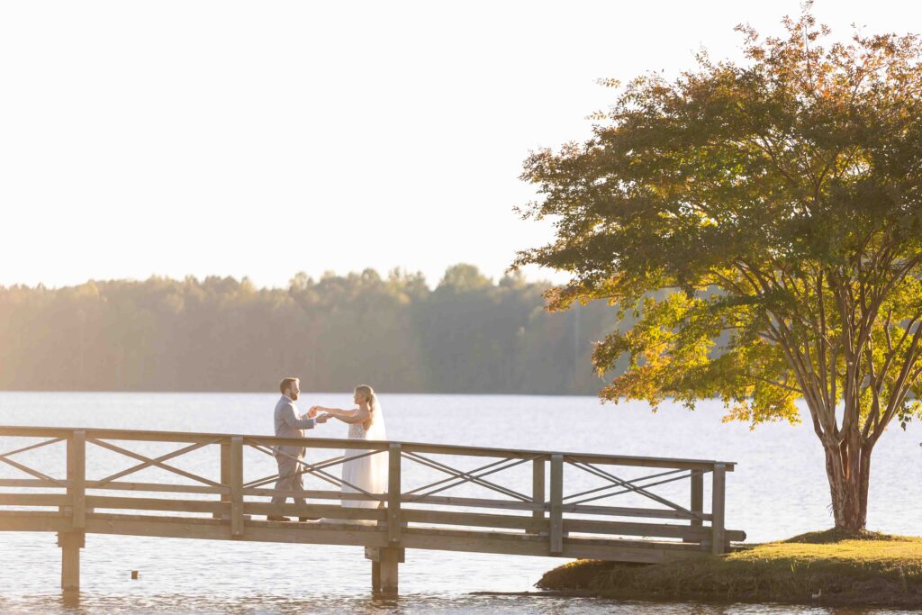 bride and groom walking on a bridge during golden hour