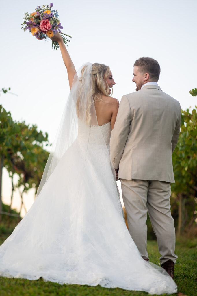 romantic bridal portrait in a vineyard setting with colorful bouquet and natural light