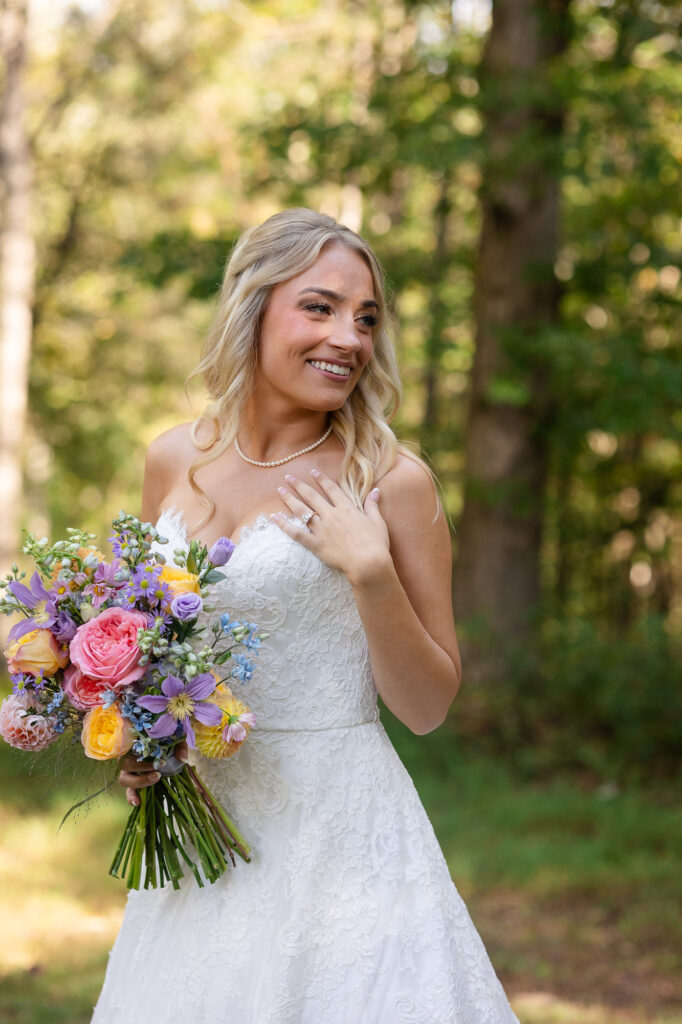 bride poses with her floral bouquet during vineyard wedding in Georgia