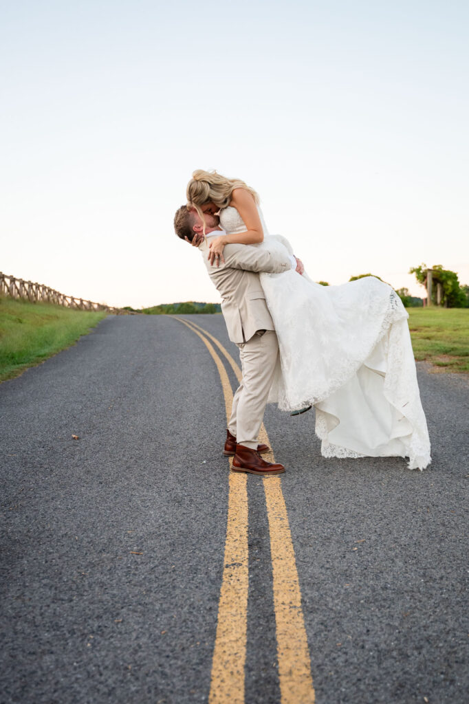 groom lifts his bride during their wedding portraits in north georgia