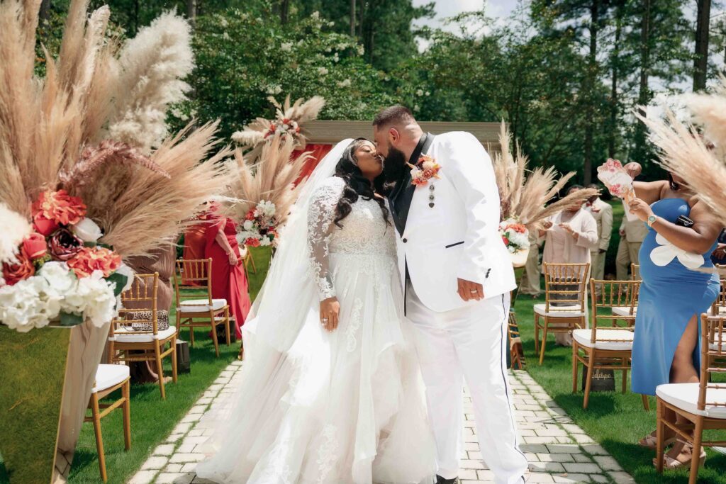 Bride and groom share a kiss during their Castle at the Wildwood Gardens ceremony,