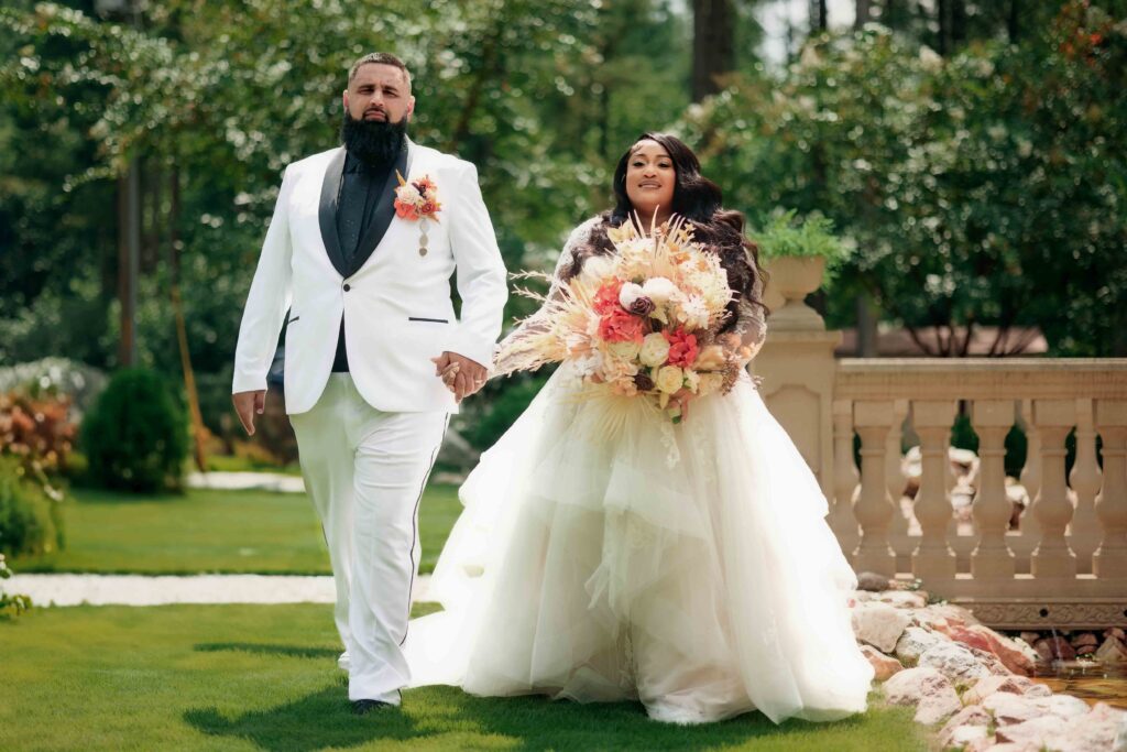 Newlyweds walking hand in hand near castle entrance at The Castle at Wildwood Gardens venue