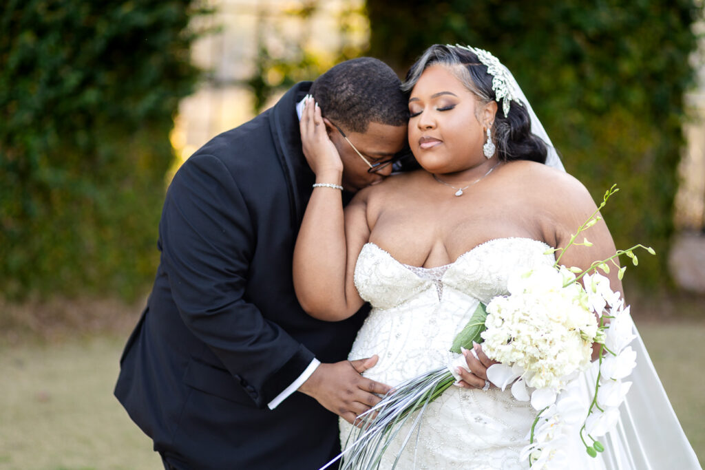 Romantic couple embrace under historic mill architecture at Bibb Mill wedding