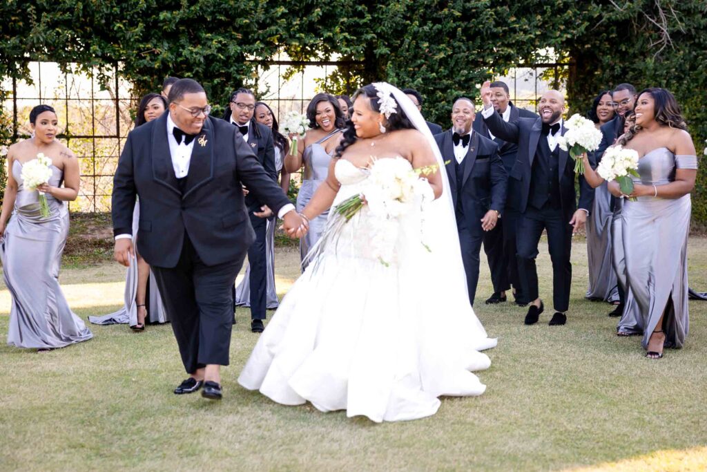 Candid moment of bridal party walking along Bibb Mill pathways during wedding day