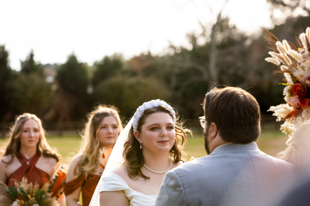 bride looking at her husband during wedding ceremony at Beautiful Beginnings Farm