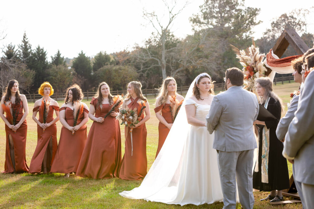 bride holds groom hands  at wedding ceremony Beautiful Beginnings Farm