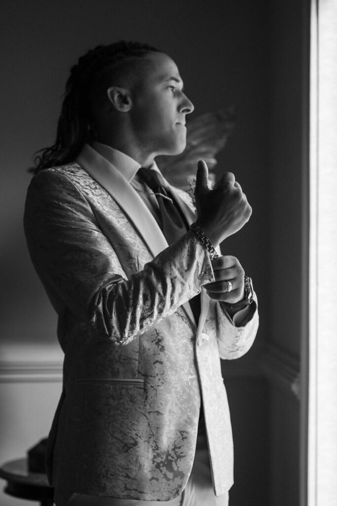 groom looking out the window while waiting on his wedding to begin at Pristine chapel in Atlanta 