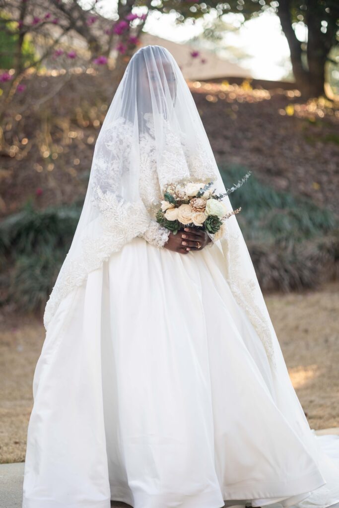 bride posing with vail at her wedding at Pristine chapel in Atlanta 